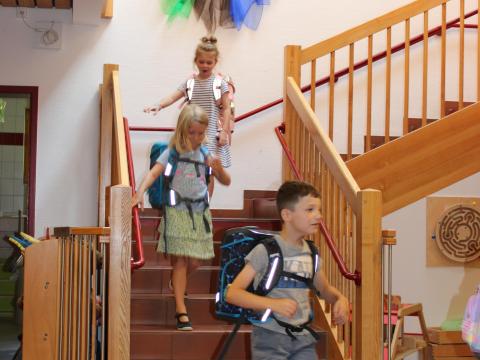 Drei Kinder gehen die Treppe in der Kita herunter