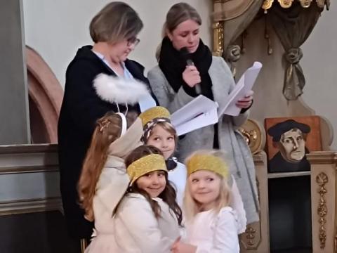 Drei als Engel verkleidete Kinder und zwei Erwachsene