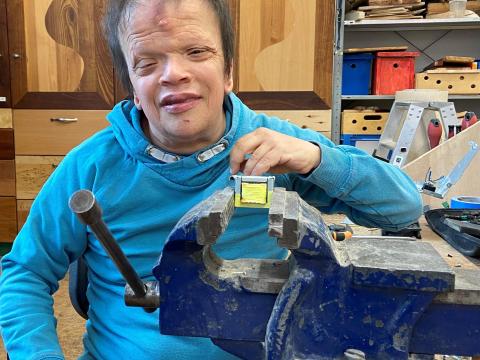 Mann am Schraubstock beim Zerlegen von Elektroschrott