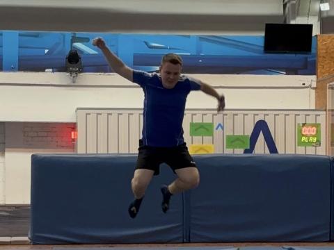 Person springt auf dem Trampolin.
